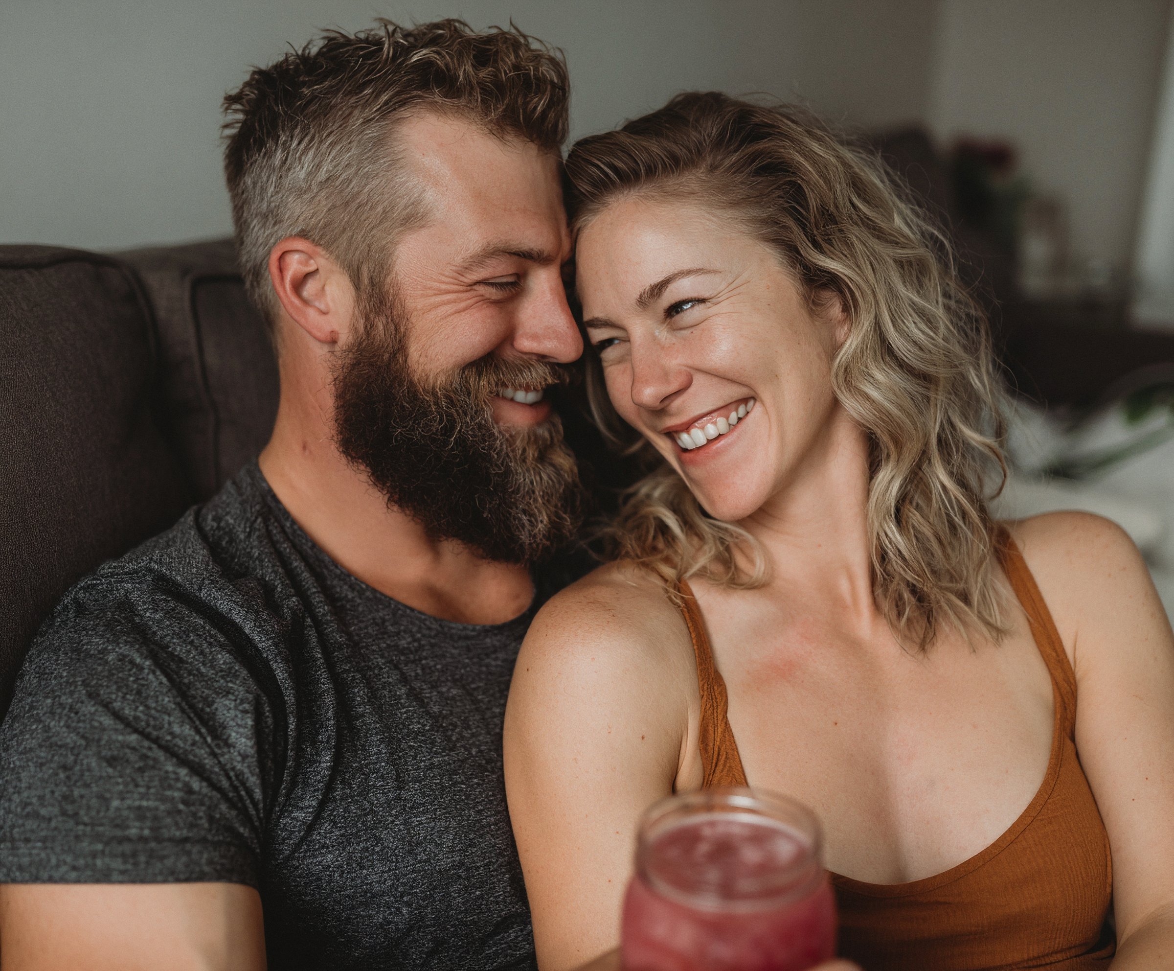 Couple sharing a smoothie on a couch